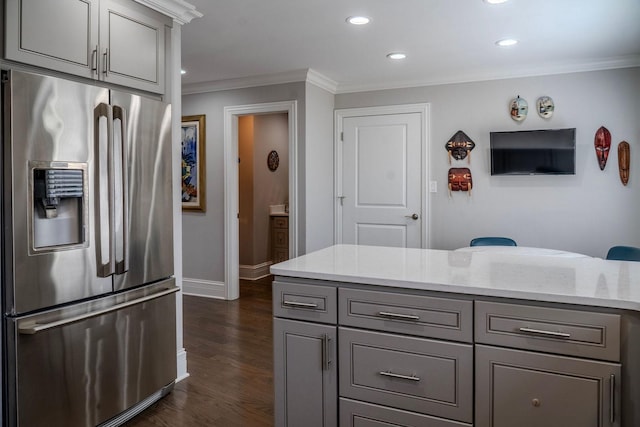 kitchen featuring gray cabinetry, dark wood finished floors, stainless steel fridge, crown molding, and light stone countertops