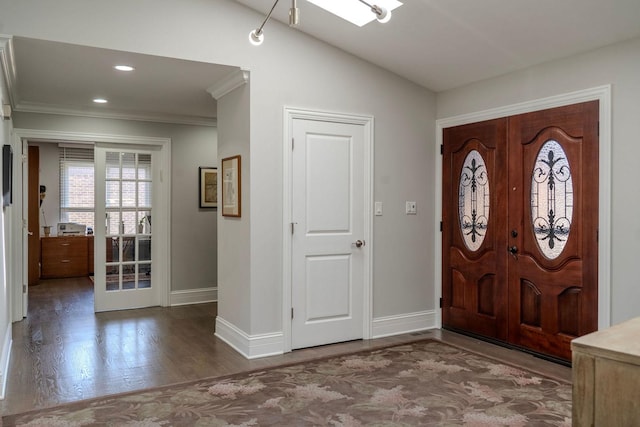 foyer entrance with ornamental molding, wood finished floors, recessed lighting, baseboards, and vaulted ceiling