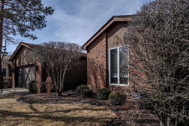 view of home's exterior featuring brick siding, driveway, and a garage