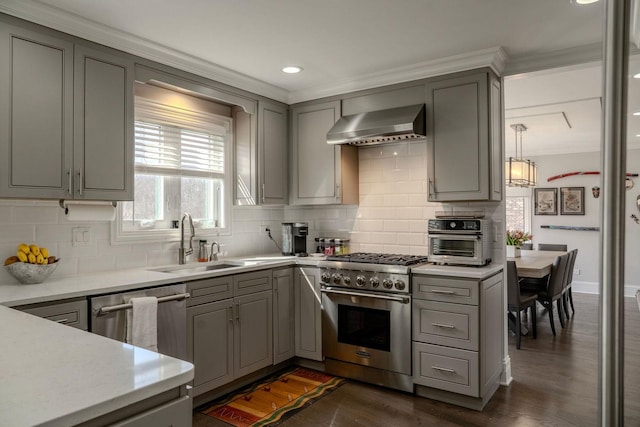 kitchen with gray cabinetry, stainless steel appliances, wall chimney exhaust hood, and a sink