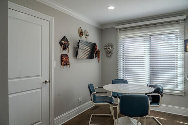 dining area featuring wood finished floors, baseboards, and ornamental molding