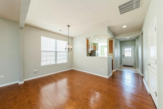 interior space with an inviting chandelier, baseboards, visible vents, and dark wood-style flooring