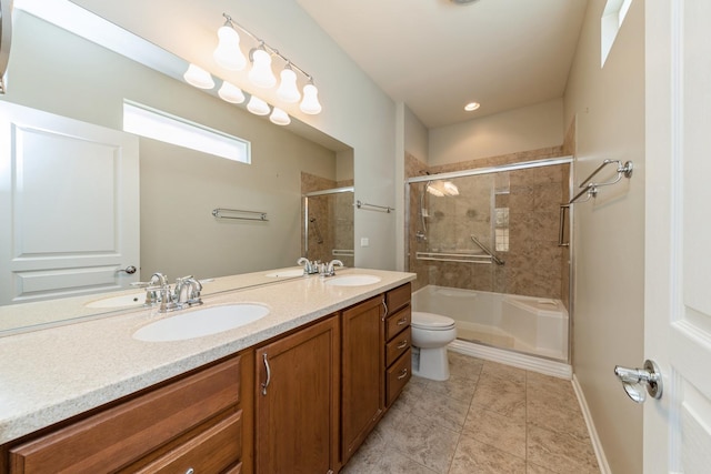 bathroom featuring toilet, a tile shower, and a sink