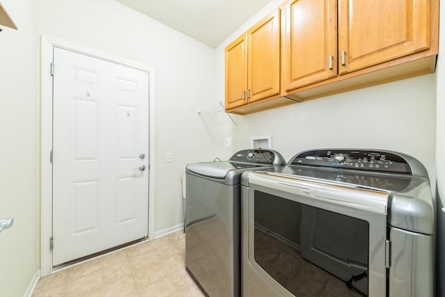 washroom with baseboards, cabinet space, and independent washer and dryer