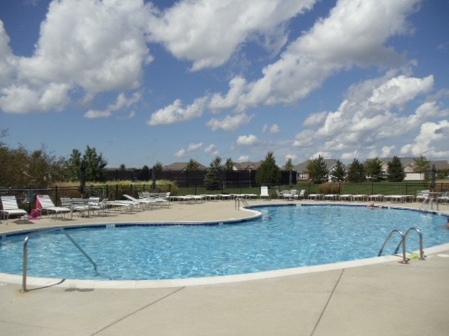 pool with a patio and fence