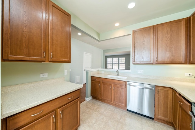 kitchen featuring dishwasher, light countertops, recessed lighting, brown cabinets, and a sink