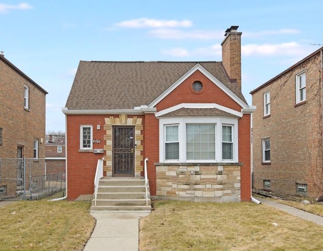 view of front of house featuring a shingled roof, a chimney, fence, and a front lawn