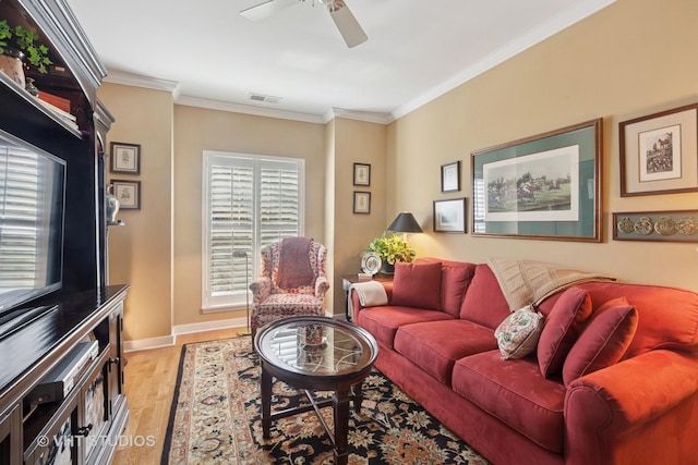 living room with visible vents, baseboards, light wood-style flooring, ceiling fan, and crown molding