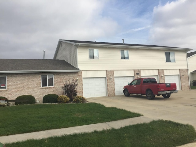 view of front of property featuring a garage, driveway, and brick siding