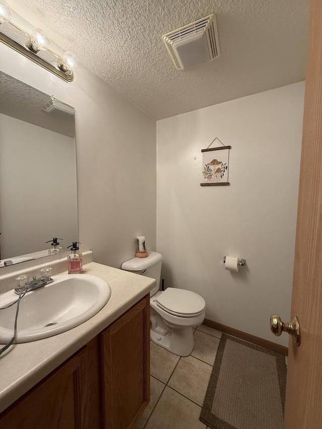 half bath with visible vents, toilet, tile patterned floors, a textured ceiling, and vanity