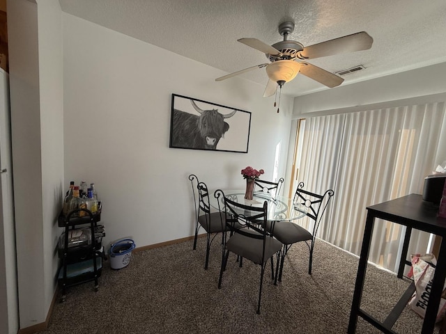 carpeted dining space with a ceiling fan, visible vents, a textured ceiling, and baseboards