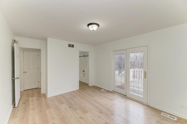 unfurnished bedroom with baseboards, light wood-type flooring, visible vents, and access to exterior