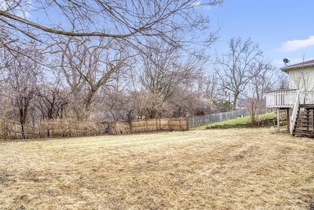 view of yard with stairs, fence, and a deck