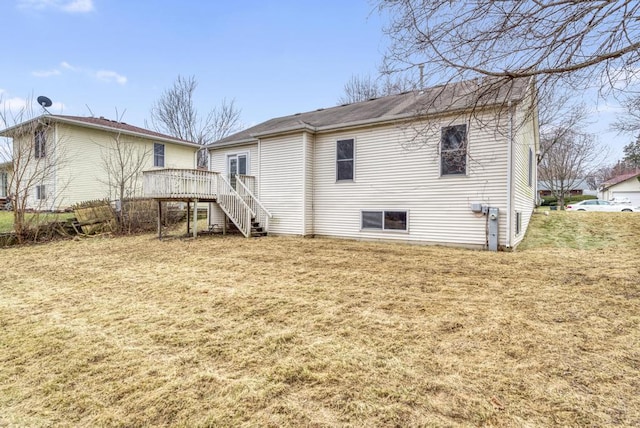 back of property with stairs, a lawn, and a wooden deck