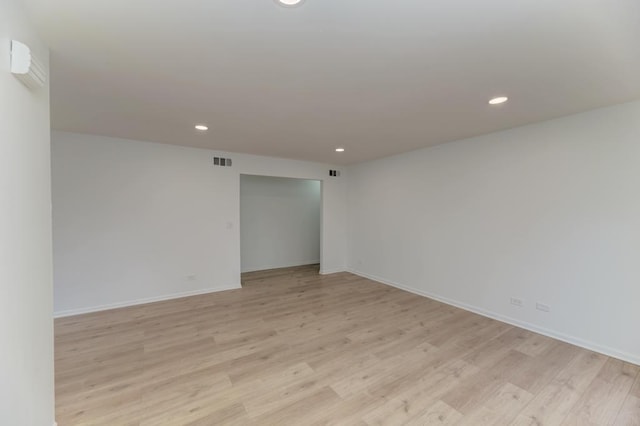 spare room with baseboards, light wood-type flooring, visible vents, and recessed lighting