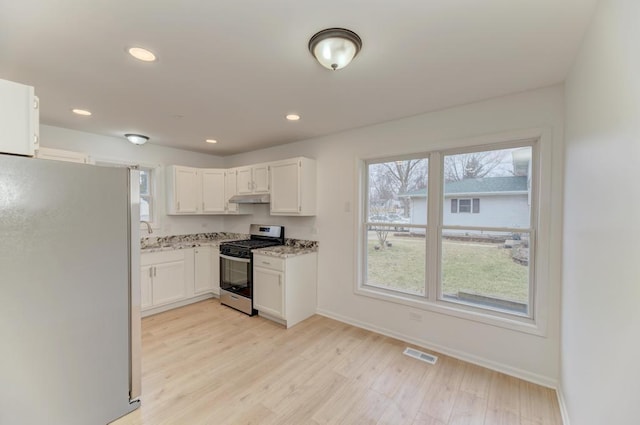 kitchen with light wood finished floors, baseboards, appliances with stainless steel finishes, under cabinet range hood, and recessed lighting