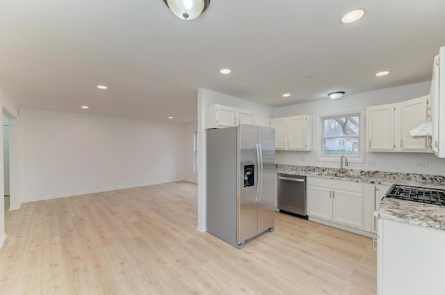 kitchen with under cabinet range hood, white cabinetry, stainless steel appliances, and light wood finished floors