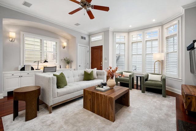 living room featuring ornamental molding, a wealth of natural light, visible vents, and light wood-style flooring