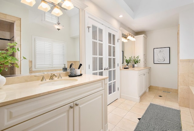 bathroom featuring tile patterned flooring, two vanities, a sink, visible vents, and french doors