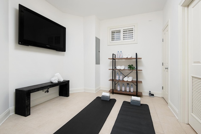 workout room with light tile patterned flooring, electric panel, and baseboards