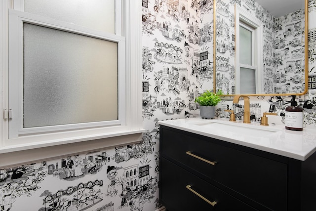 bathroom featuring vanity and wallpapered walls