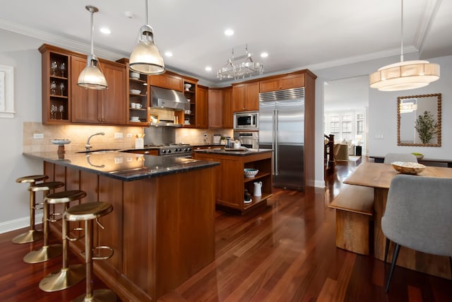 kitchen featuring built in appliances, under cabinet range hood, a sink, open shelves, and brown cabinetry