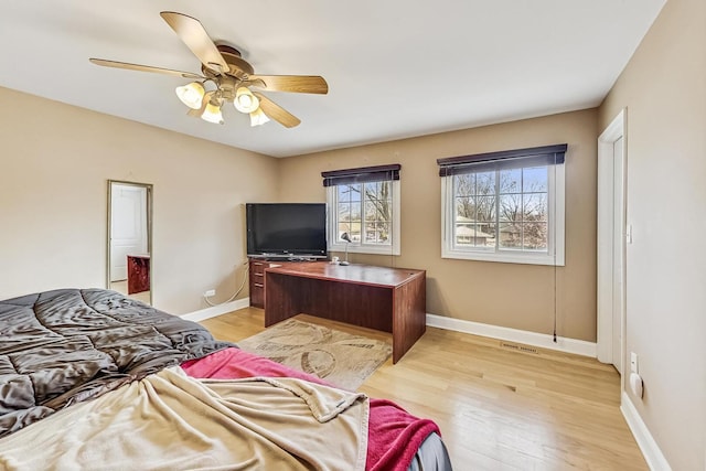 bedroom with ceiling fan, light wood-type flooring, and baseboards