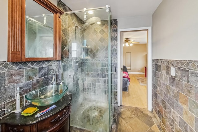 full bath featuring ensuite bath, tile walls, a shower stall, and vanity