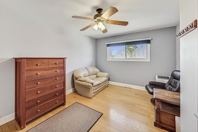 sitting room featuring baseboards, a ceiling fan, and light wood-style floors