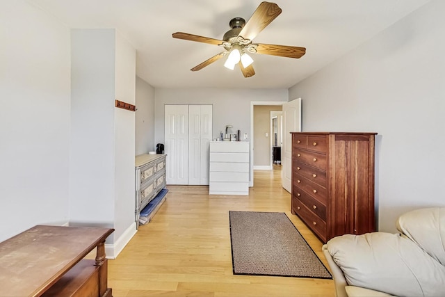 interior space with baseboards, a closet, a ceiling fan, and light wood-style floors