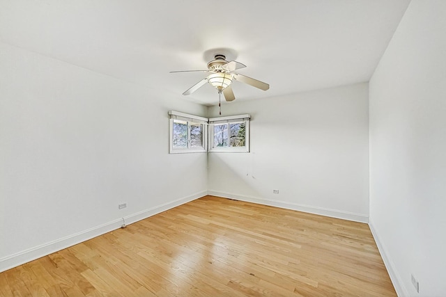 spare room featuring a ceiling fan, light wood-style flooring, and baseboards