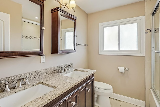 full bathroom featuring toilet, a shower with door, baseboards, and a sink