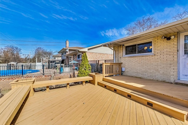 wooden terrace with fence and a fenced in pool