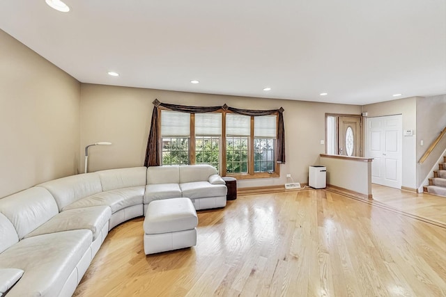 unfurnished living room featuring stairs, light wood finished floors, baseboards, and recessed lighting