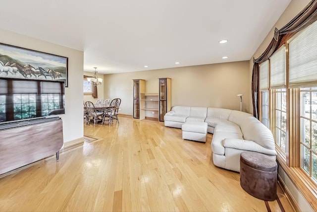 living room with light wood-style floors, baseboards, a notable chandelier, and recessed lighting