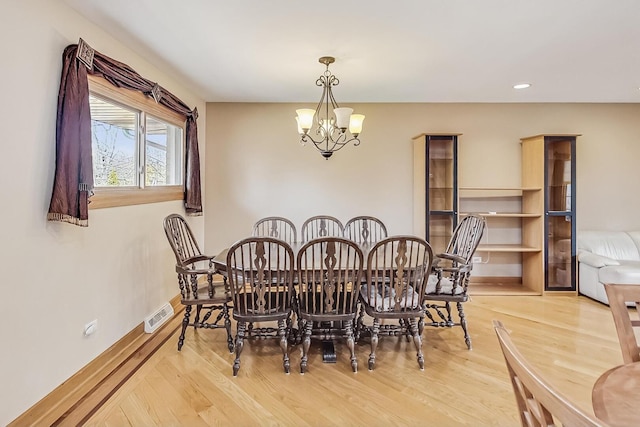 dining space with recessed lighting, visible vents, an inviting chandelier, wood finished floors, and baseboards