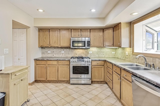 kitchen with light tile patterned flooring, recessed lighting, stainless steel appliances, a sink, and backsplash