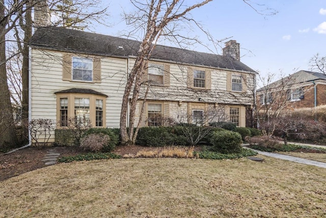 view of front of property featuring a chimney and a front yard