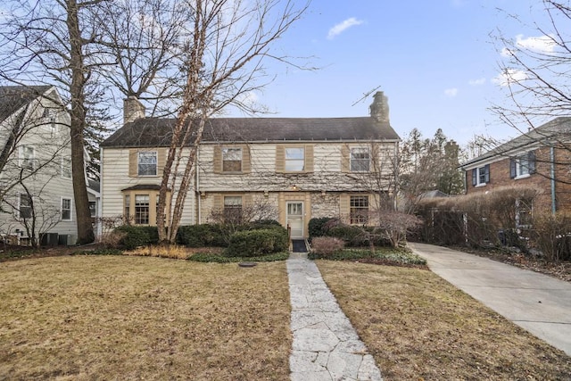 view of front of property with a chimney and a front lawn