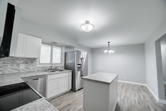 1978 Fleming St, Watseka, IL 60970 - kitchen with appliances with stainless steel finishes, a sink, light wood finished floors, and a center island
