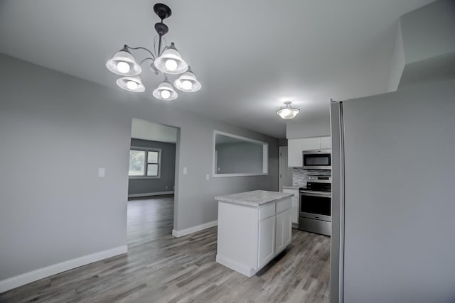 1978 Fleming St, Watseka, IL 60970 - kitchen with stainless steel appliances, white cabinetry, light countertops, light wood-style flooring, and baseboards