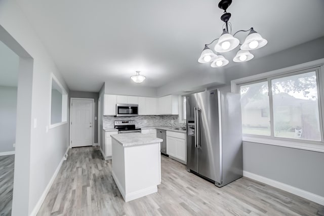 1978 Fleming St, Watseka, IL 60970 - kitchen with appliances with stainless steel finishes, light wood-type flooring, white cabinetry, baseboards, and a center island