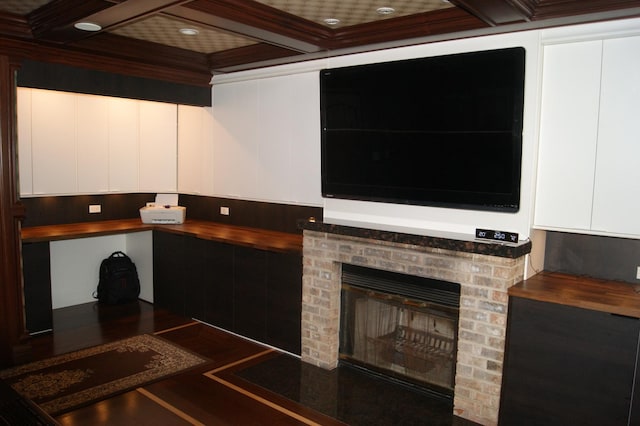 kitchen featuring coffered ceiling, wood counters, a fireplace, white cabinetry, and beam ceiling