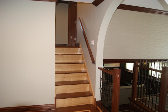 staircase featuring arched walkways