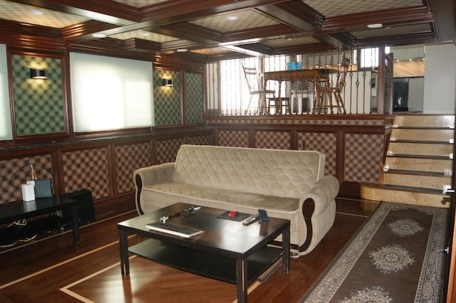 living room with beam ceiling, coffered ceiling, and wood finished floors