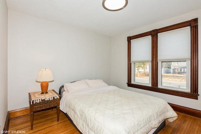 bedroom with light wood-type flooring and baseboards