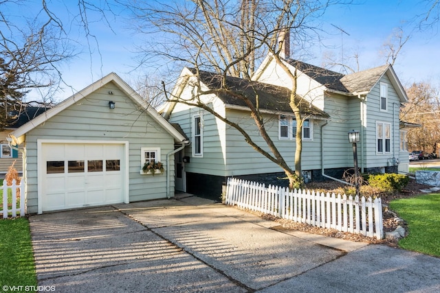 view of property exterior with concrete driveway, a detached garage, an outdoor structure, and fence