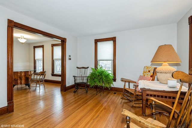 living area with baseboards and light wood finished floors