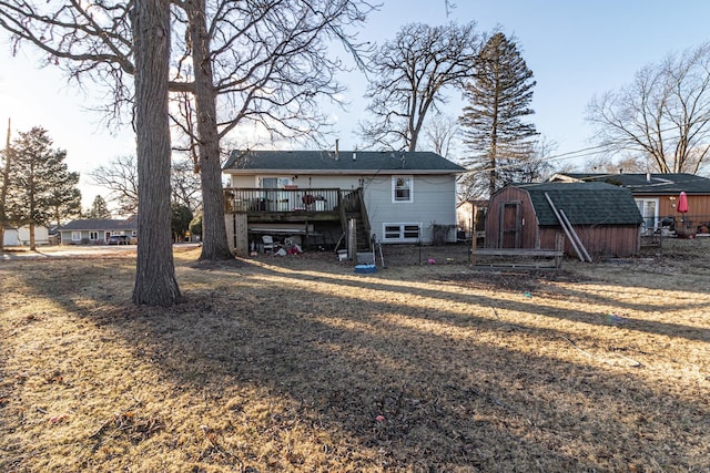 rear view of house featuring stairway, an outdoor structure, a wooden deck, and a storage shed