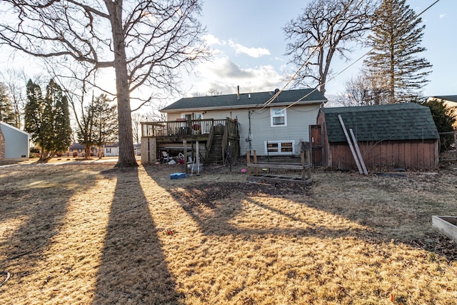 rear view of property with a shed, stairs, a wooden deck, and an outbuilding